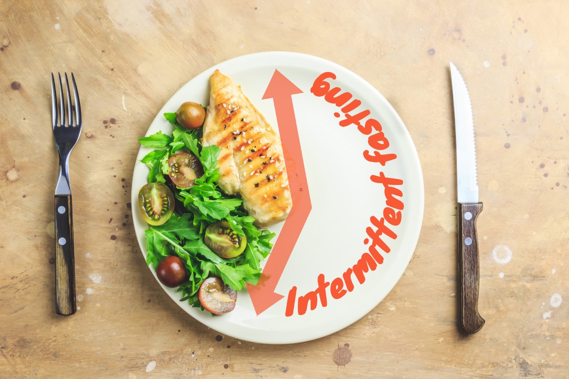 Intermittent fasting. Plate with food and watch